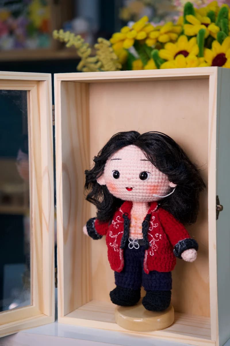 Close-up artisan detail of crochet doll facial features and hair